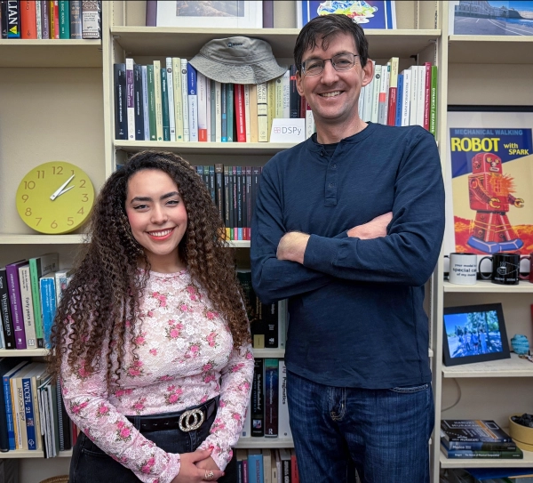 Джули Каллини и Кристофер Поттс перед полной книжной полкой