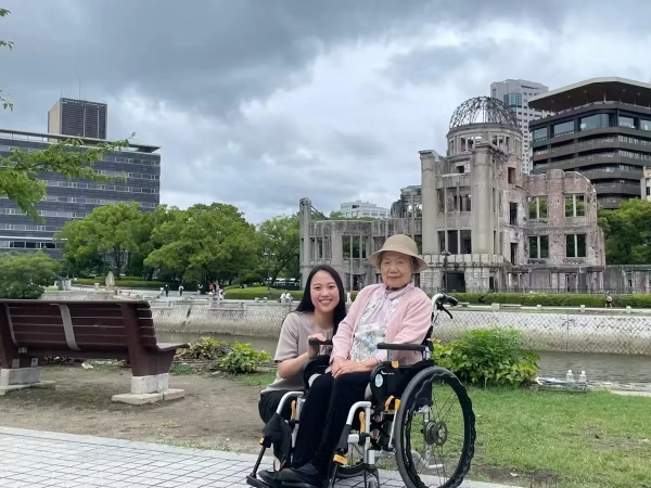 На изображении может присутствовать Дэн Инчао, одежда, шляпа, скамейка, мебель, достопримечательность и мемориальный парк мира в Хиросиме.