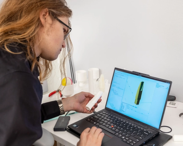 Алекс за ноутбуком с прототипом в одной руке