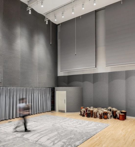 фигура в движении идет к нескольким традиционным деревянным барабанам