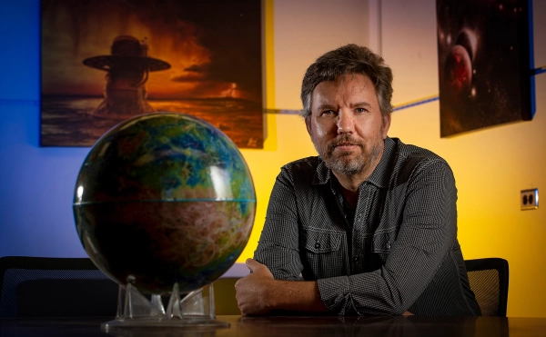 Почему Венера — это Ад, а Земля — Эдем? 3 Мужчина сидит рядом с глобусом