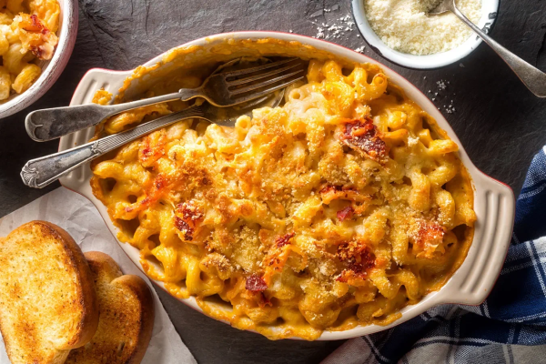 Macaroni & Cheese в американском стиле: похожую на кашу констистенцию даёт соус бешамель, а ярко-жёлтый цвет — сыр чеддер, который традиционно принято подкрашивать до почти оранжевого состояния. Кроме того, американцы нередко доводят блюдо в духовке для образования сырной корочки Macaroni & Cheese в американском стиле: похожую на кашу констистенцию даёт соус бешамель, а ярко-жёлтый цвет — сыр чеддер, который традиционно принято подкрашивать до почти оранжевого состояния. Кроме того, американцы нередко доводят блюдо в духовке для образования сырной корочки