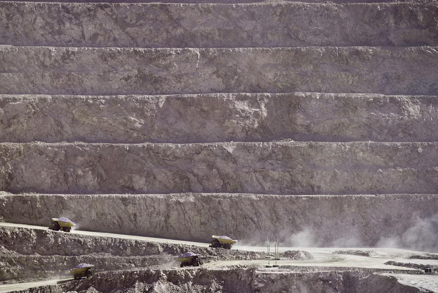 Самосвалы вывозят грунт с базы в Эскондида-Норте, провинция открытый медный рудник на севере Чили. Входящий в состав комплекса Minera Escondida, массивный грузовик доставляет материал из карьера почти час в оба конца.