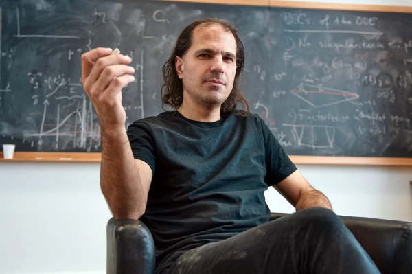 Модели оригами помогают решить сложную физическую загадку 6 Мужчина с волосами до плеч сидит в кресле.