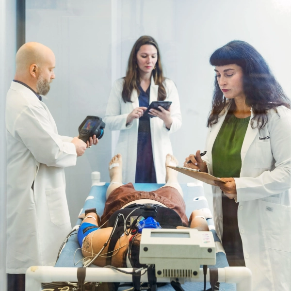 три члена медицинской бригады готовятся к операции у человека на каталке