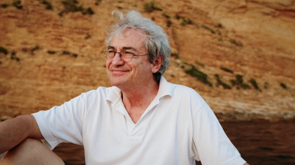 Мужчина в очках улыбается