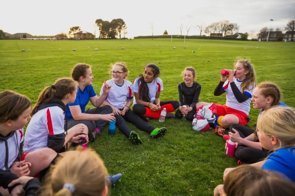 Аутизм может иметь подтипы, которые генетически отличаются друг от друга. 3 Группа девочек-подростков и их тренер обсуждают игру.