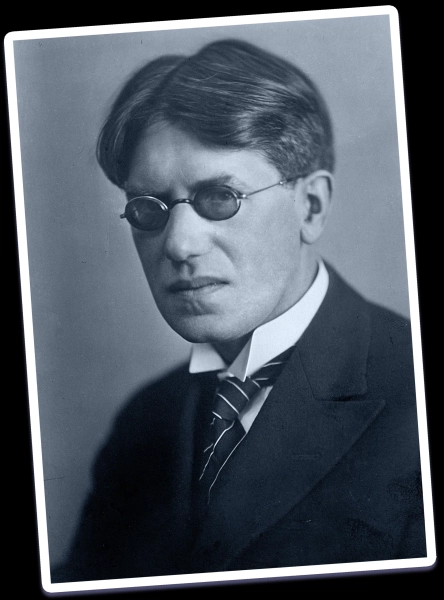 Черно-белый погрудный портрет мужчины со строгим взглядом, в затемненных очках и с короткими волосами, разделенными пробором по центру.