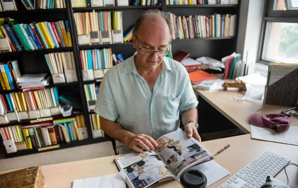 Грэнвилл листает книгу «Главные подозреваемые» — графический роман в жанре детектива на математическую тематику, написанный им в соавторстве со старшей сестрой.