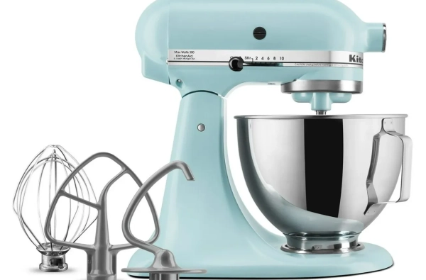 Синий миксер с тремя насадками рядом с ним.