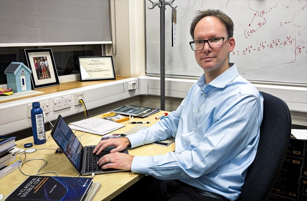 Физики, изучающие элементарные частицы, обнаружили «магию» на Большом адронном коллайдере 3 Пара фотографий одинаково выглядящих мужчин в своих офисах.