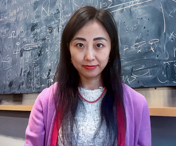 Космический парадокс раскрывает ужасные последствия существования Вселенной без наблюдателя 4 Женщина в розовом свитере перед меловой доской.