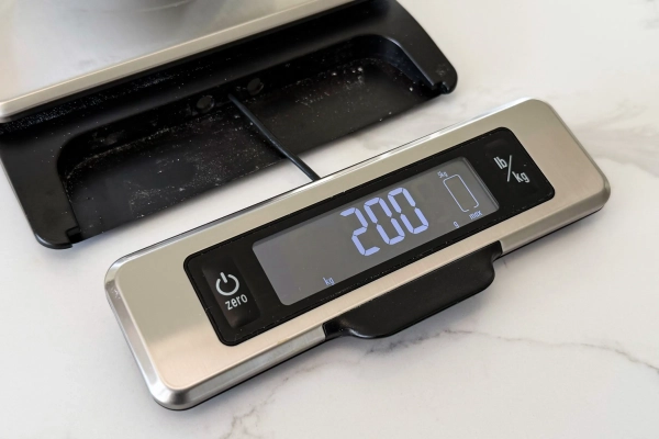 Передняя часть кухонных весов с выдвинутой светодиодной панелью, подключенной одним проводом.