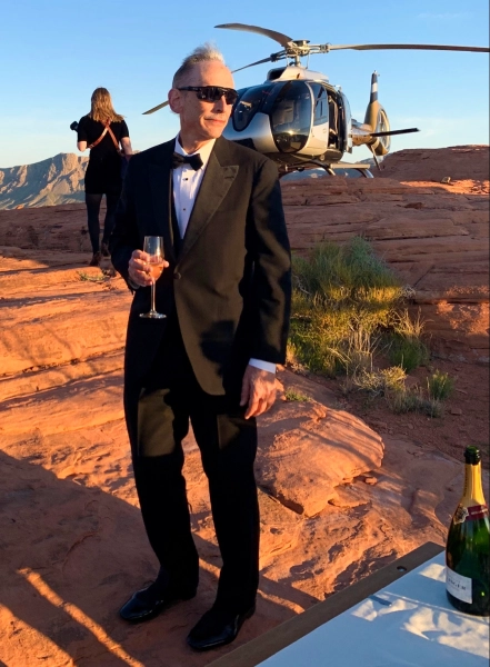 Мужчина в костюме Джеймса Бонда на фоне вертолета.