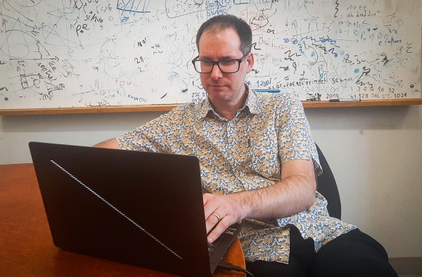 Физики, изучающие элементарные частицы, обнаружили «магию» на Большом адронном коллайдере 2 Пара фотографий одинаково выглядящих мужчин в своих офисах.