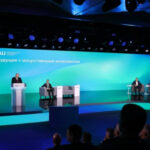 Конференция на тему "Будущее с искусственным интеллектом", выступление спикеров на сцене.