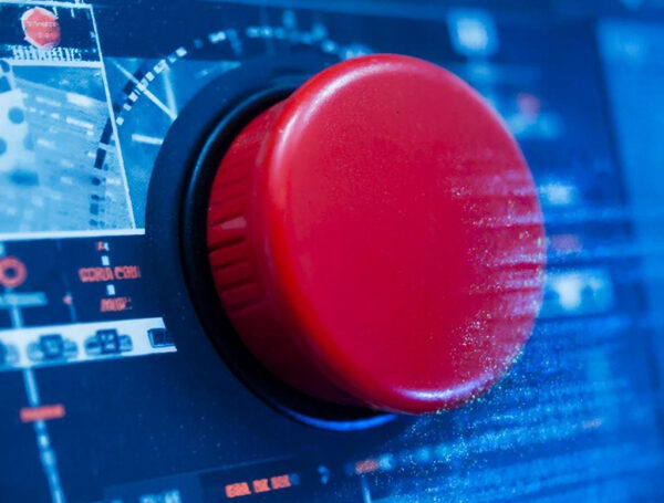 Красная кнопка на панели управления в технологическом окружении.