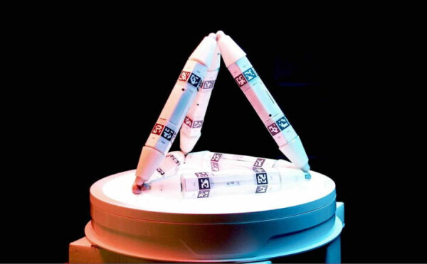 Роботизированные манипуляторы на круглой платформе с бирками для движения, темный фон.