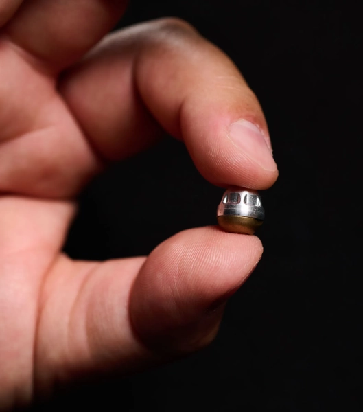 рука держит сферический металлический предмет