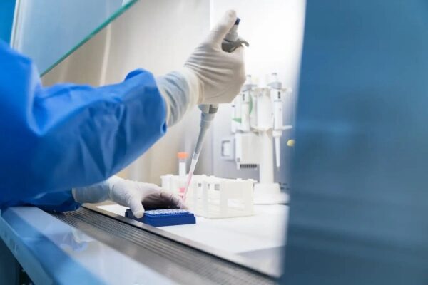 Лабораторные исследования: учёный использует пипетку в стерильных условиях.