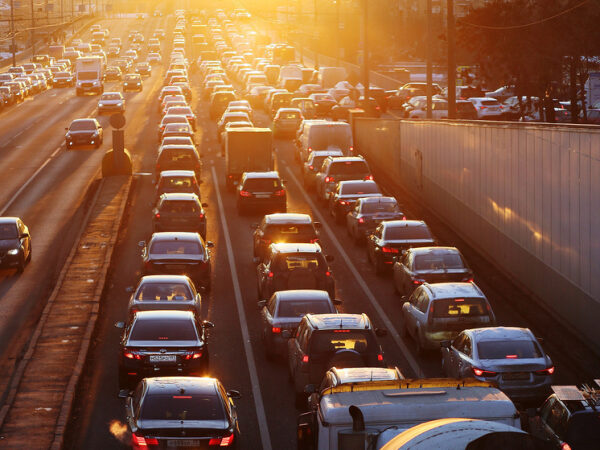 Автомобильная пробка на городской дороге в лучах закатного солнца.