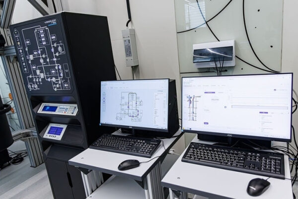 Настройка промышленного оборудования: два монитора с техническими схемами.