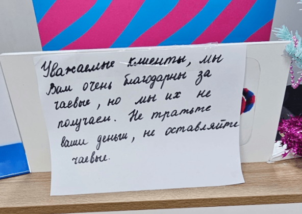 Записка на русском: сотрудники не получают чаевые, просьба их не оставлять.