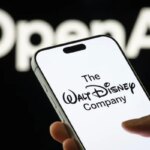 Смартфон с логотипом Disney на фоне текста OpenAI, в руке человека.