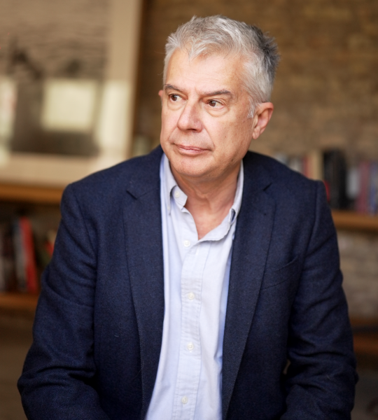 Мужчина стоит, засунув руки в карманы.