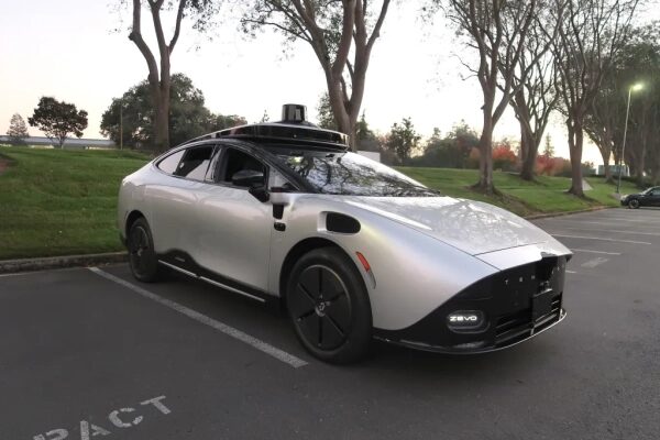 Серый автономный электромобиль на парковке, вечер, без людей.