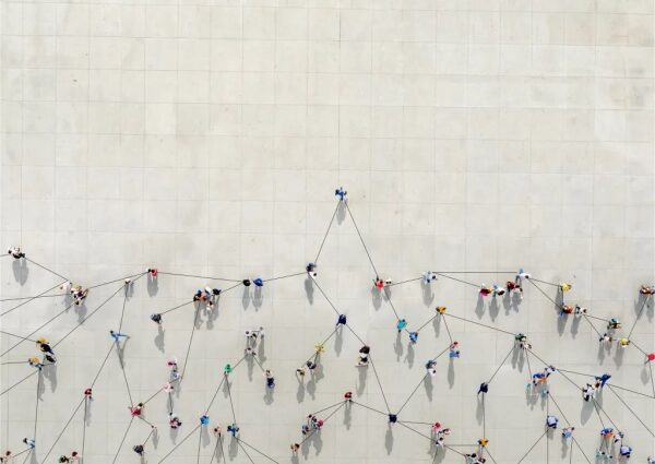 Люди, связанные линиями, на серой поверхности. Вид сверху, абстрактная композиция.