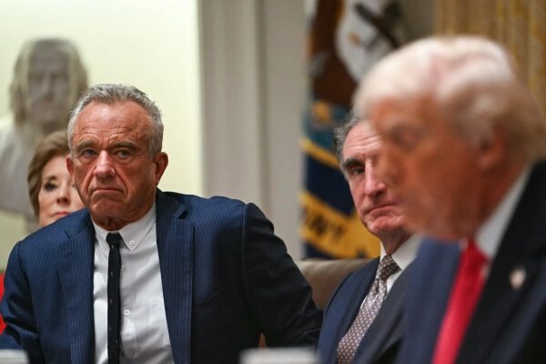 Официальное мероприятие в конференц-зале; мужчины обсуждают что-то важное.