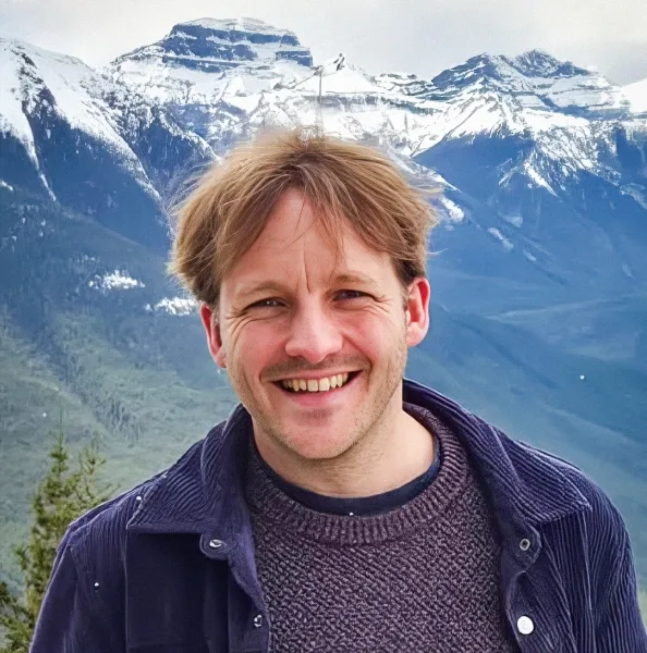 Экстремальные климатические явления — отличительная черта эпохи животных. 7 Улыбающийся мужчина стоит на фоне гор.