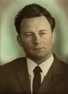 Мужчина в костюме на портретной фотографии винтажного стиля.