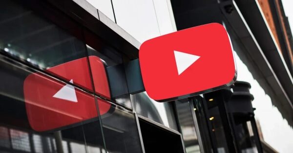 Логотип YouTube на фасаде здания, отражается в стекле.