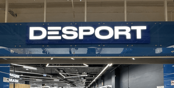 Вывеска магазина "Desport" на синем фоне в торговом центре.