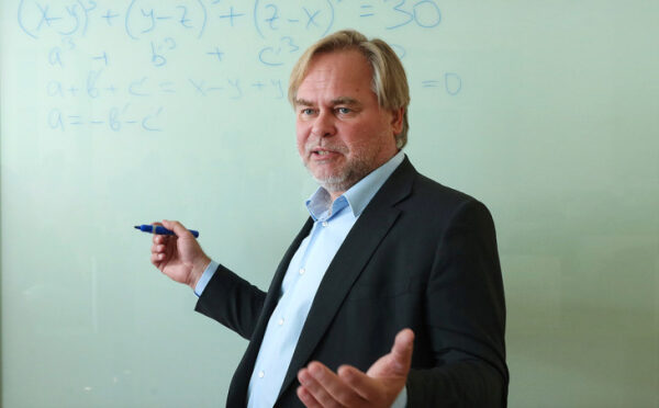 Человек объясняет формулы на доске.