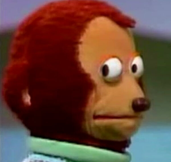 Плюшевый персонаж с удивленным выражением лица на голубом фоне.