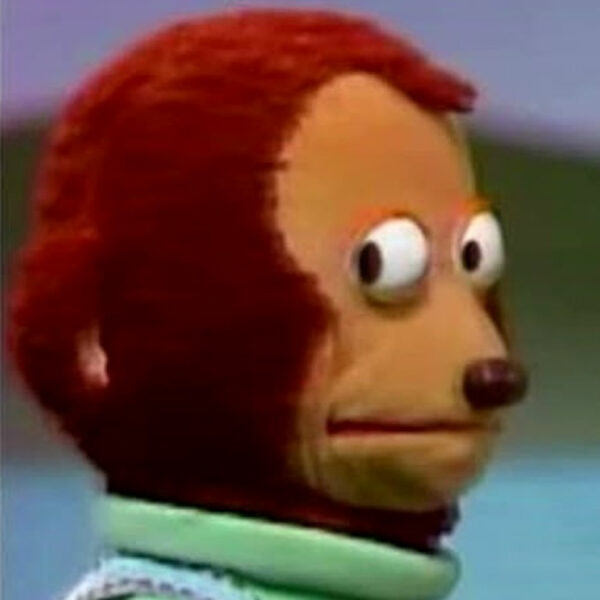 Плюшевый персонаж с удивленным выражением лица на голубом фоне.