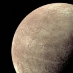 Изображение спутника Юпитера Европы с ледяной поверхностью и трещинами.