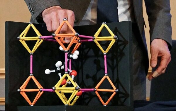 Этот химик, лауреат Нобелевской премии, мечтает создать воду из воздуха. 2 рука держит модель шара и палки