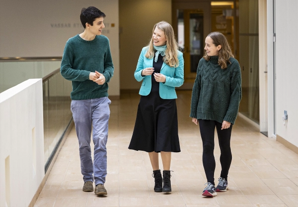 Три человека идут по коридору по направлению к камере.