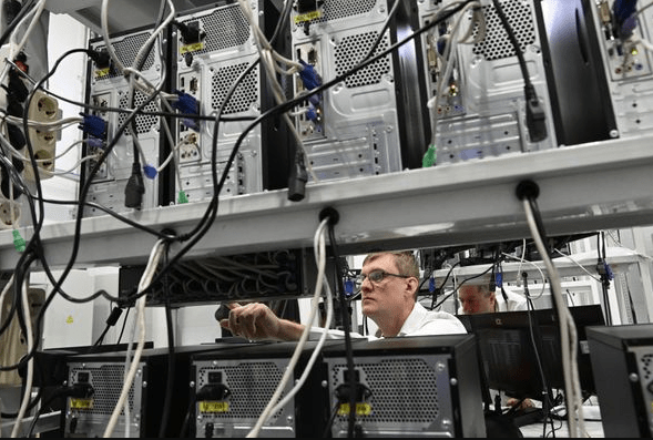 Серверная комната с рядами компьютеров и переплетение кабелей. Техническое обслуживание оборудования.