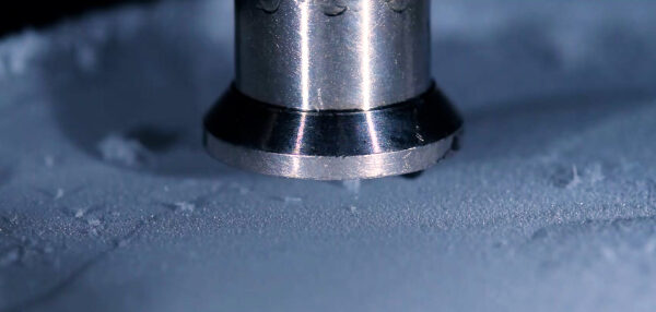 Металлическая насадка крупным планом на морозной поверхности.