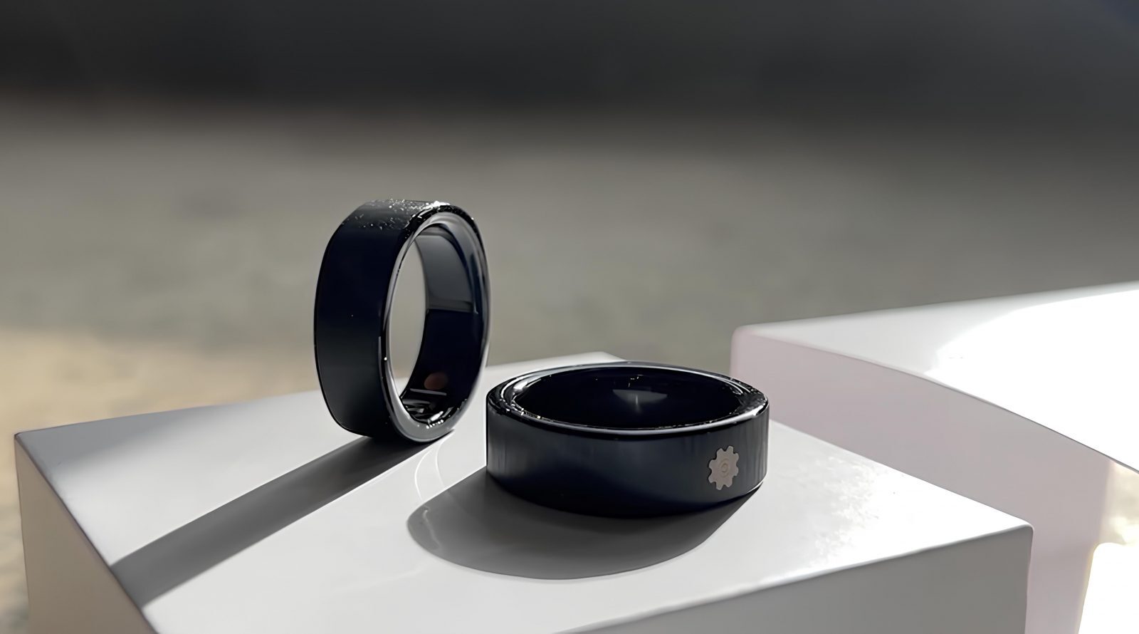 Автономное «умное» кольцо Smalth Titanium из титана 9 Чёрные кольца на белой поверхности, обручальные аксессуары, минималистичный дизайн.