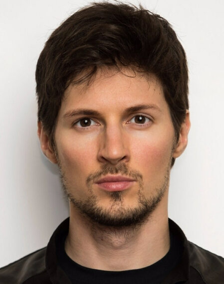 Изображение человека с темными волосами и бородой на светлом фоне.