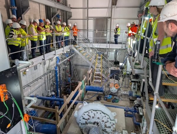 Изображение может содержать: человека, рабочего, архитектурное здание, завод, производство шлемов, мастерскую для взрослых и одежду.