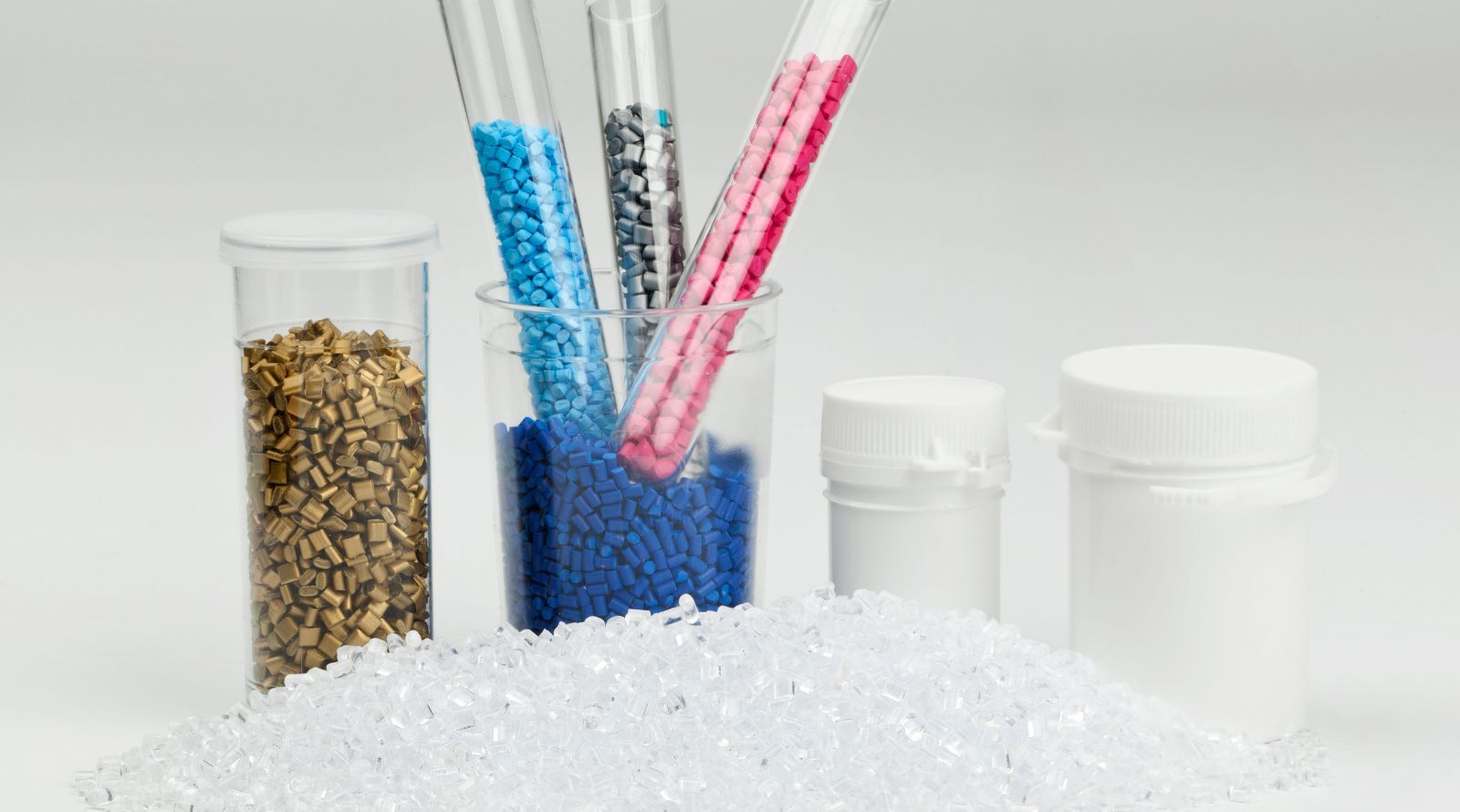 Целлюлоза против микропластика: прорыв японских учёных 1 Пластиковые гранулы разных цветов в пробирках и контейнерах на белом фоне.