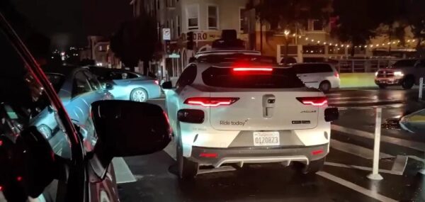 Автомобили на ночной улице, задние фонари светят в темноте.