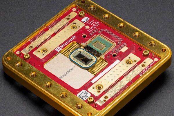 Золотистый металлический корпус с винтами и красной схемой на темно-сером фоне.